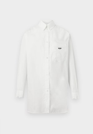 Langermet hvit skjorte med knapper og en brystlomme foran med liten svart "Moschino"-logo.