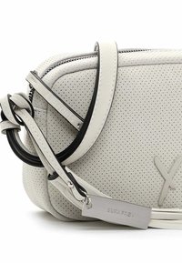 Hvid perforeret lædertaske med lynlås, sortkantet rem og metalmærke med indgravering "SURI FREY" på hvid baggrund.