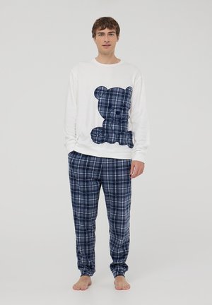 Camicetta bianca a maniche lunghe con un design di orso in plaid blu, abbinata a pantaloni da pigiama in plaid blu. Tessuto morbido con una vestibilità relaxed.
