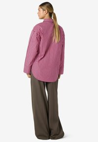 Long-sleeved, pink and white striped shirt with a classic collar, paired with wide-legged, dark brown trousers. Smooth fabric texture.