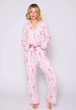 Roze pyjama set met lange mouwen en broek, voorzien van een speels patroon van notenkrakers en harten. Lichtgewicht, zacht stof met een ontspannen fit.
