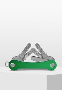 Grön multiverktyg med verktyg i rostfritt stål, som innehåller olika verktyg inklusive kniv och skruvmejslar, kompaktdesign med en slät yta.