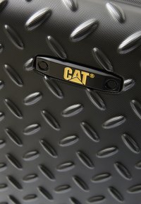Schwarze, gemusterte Oberfläche mit erhobener Diamantstruktur. Enthält ein schwarzes Metall-Logo-Platte von CAT mit goldener Schrift. Strapazierfähiges Material.
