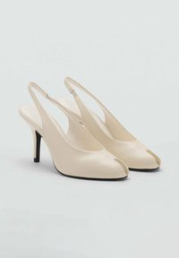 Décolleté beige in pelle con cinturino e tacco a stiletto nero, con punta divisa, su uno sfondo chiaro e semplice.