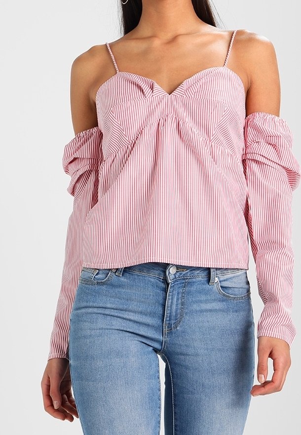 Punavalkoraidallinen olkapäät paljastava pusero, jossa ohuet olkaimet, poimutettu etusauma ja pitk ät pörröiset hihat. Yhdistetty vaaleansinisten farkkujen kanssa.