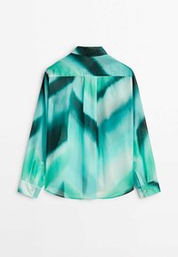 Blouse teinte dans des tons turquoise et noir, dotée d'un col, de manches longues et d'un léger éclat avec des motifs abstraits au dos.