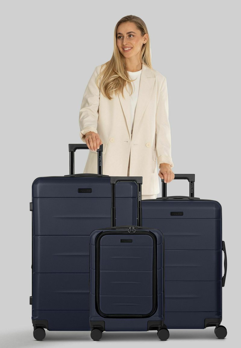 Juego de equipaje rígido azul marino con tres tamaños: grande, mediano y de cabina. Cuenta con superficies texturizadas y asas extensibles con ruedas.