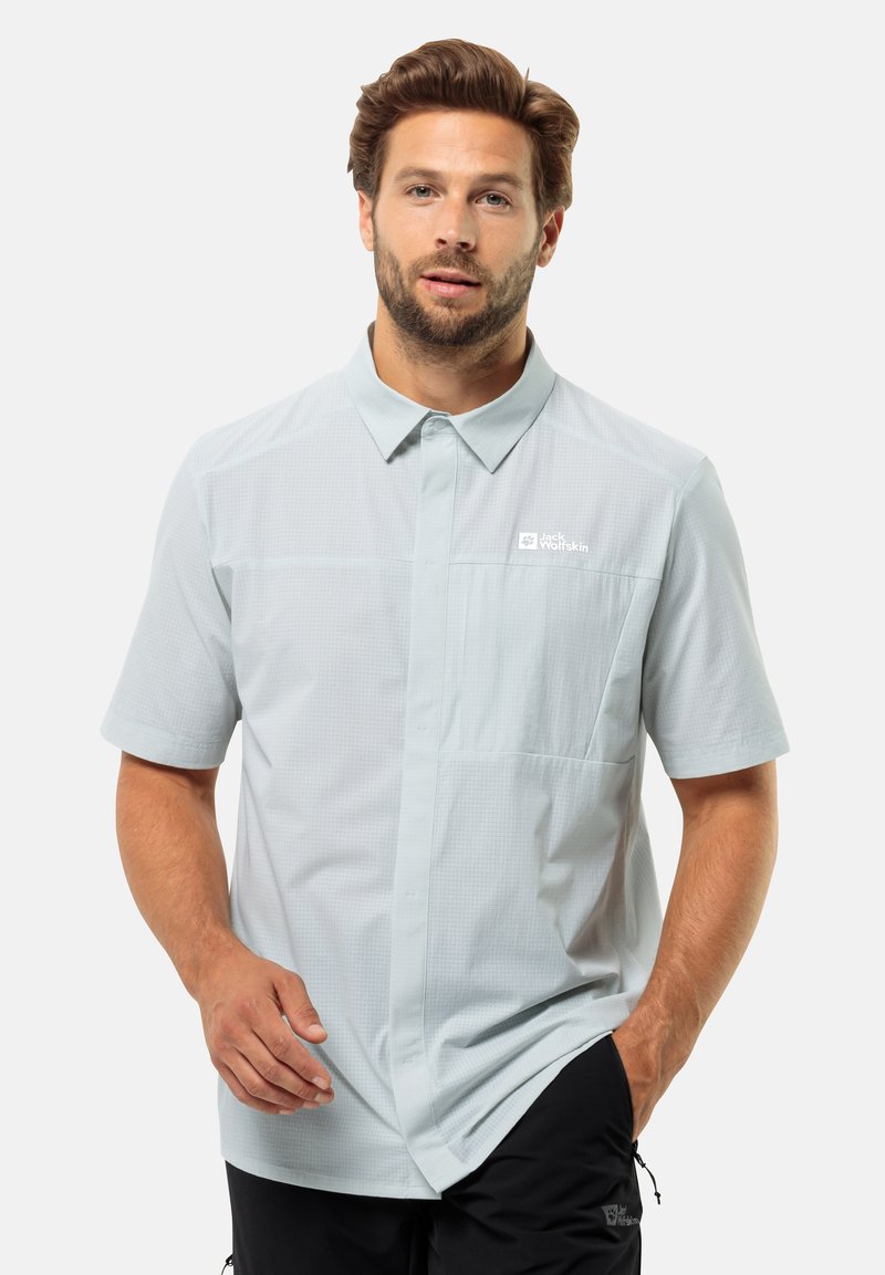 Lichtblauw kortemouwenshirt met een button-down kraag, textuurstof en een borstzak met een logo. Draag met donkere broeken.