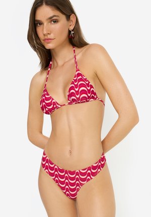 Bikini-Set in Pink mit wellenförmigen weißen Mustern. Dreieck-Top mit Neckholder und niedrig geschnittene Unterteile, die zum Design des Oberteils passen. Glatte Stoffstruktur.
