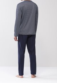 Top a maniche lunghe a righe blu navy con scollatura rotonda, abbinato a pantaloni blu navy. Il tessuto sembra morbido e leggero. Nessun motivo visibile.