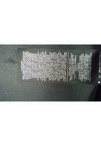 Étiquette de vêtement indiquant les matériaux en plusieurs langues : 76 % polyester, 24 % élasthanne, fabriqué au Vietnam, avec conseils d'entretien et détails du fabricant.