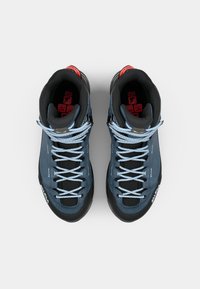 Scarpe da trekking alte blu con accenti neri, dotate di lacci azzurri, colletto imbottito e suola intermedia con motivo. Materiale resistente e superficie testurizzata.