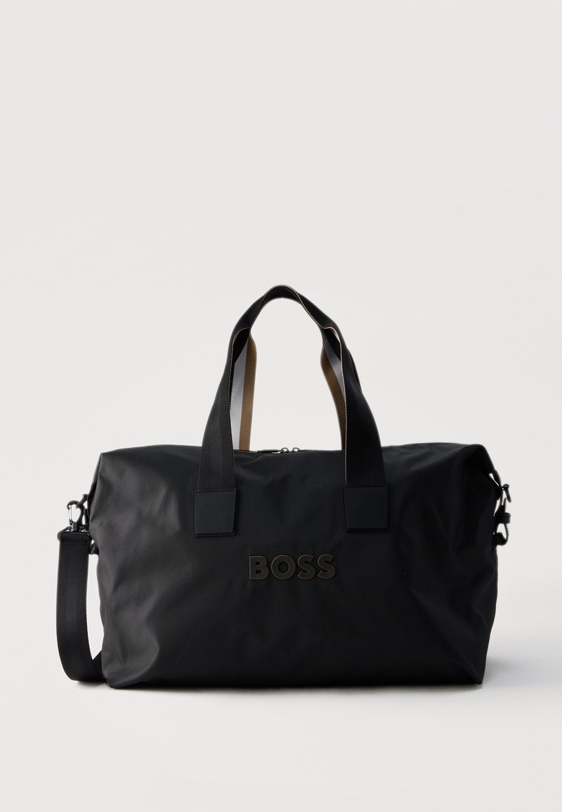 Μαύρη τσάντα BOSS τύπου duffel με διπλές λαβές και αποσπώμενο ιμάντα ώμου, απεικονίζεται σε απλό ανοιχτό φόντο.