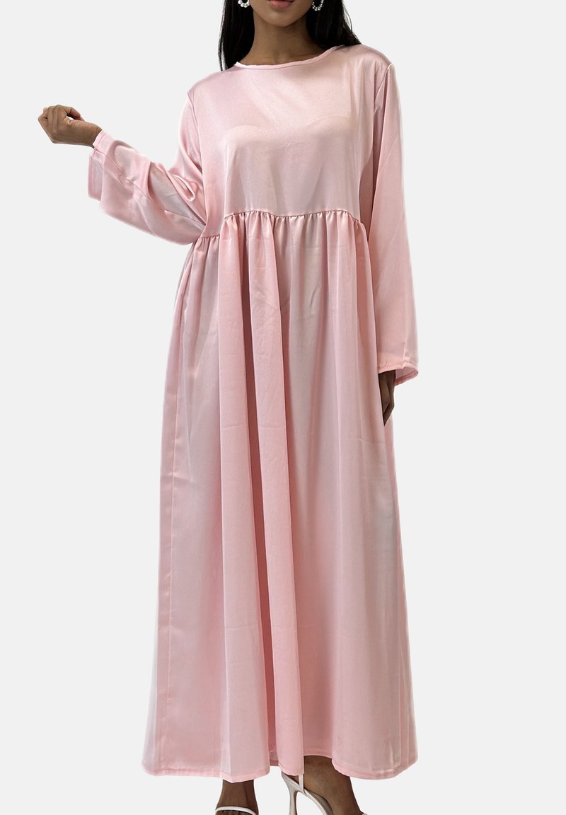 Longue robe en satin rose avec manches longues, taille froncée et poches latérales. Elle présente une texture lisse et une coupe décontractée.