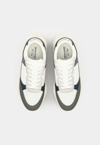 White and navy sneakers with a mesh upper, grey suede accents, flat white laces, and a textured rubber sole. Branding on the insole.
