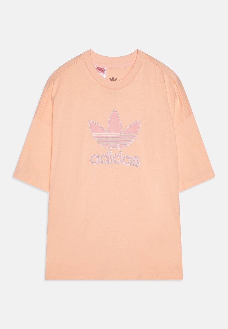 Persikų spalvos „Adidas“ marškiniai, pagaminti iš medvilnės, laisvo silueto, su trumpomis rankovėmis, puošti dideliu išsiuvinėtu logotipu balta ir rožine spalvomis.