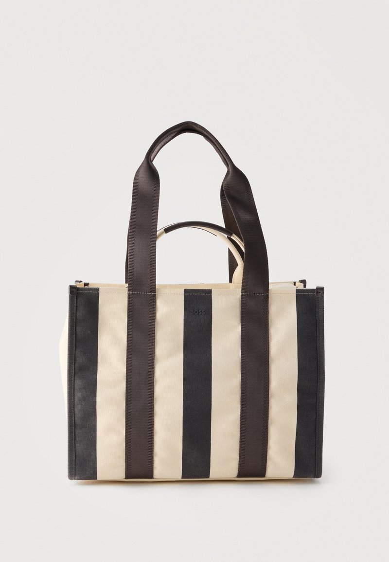 Τσάντα tote με κάθετες ρίγες σε μπεζ και μαύρο χρώμα, με δύο μακριές μαύρες λαβές και μία κοντύτερη μπεζ λαβή στη μέση.