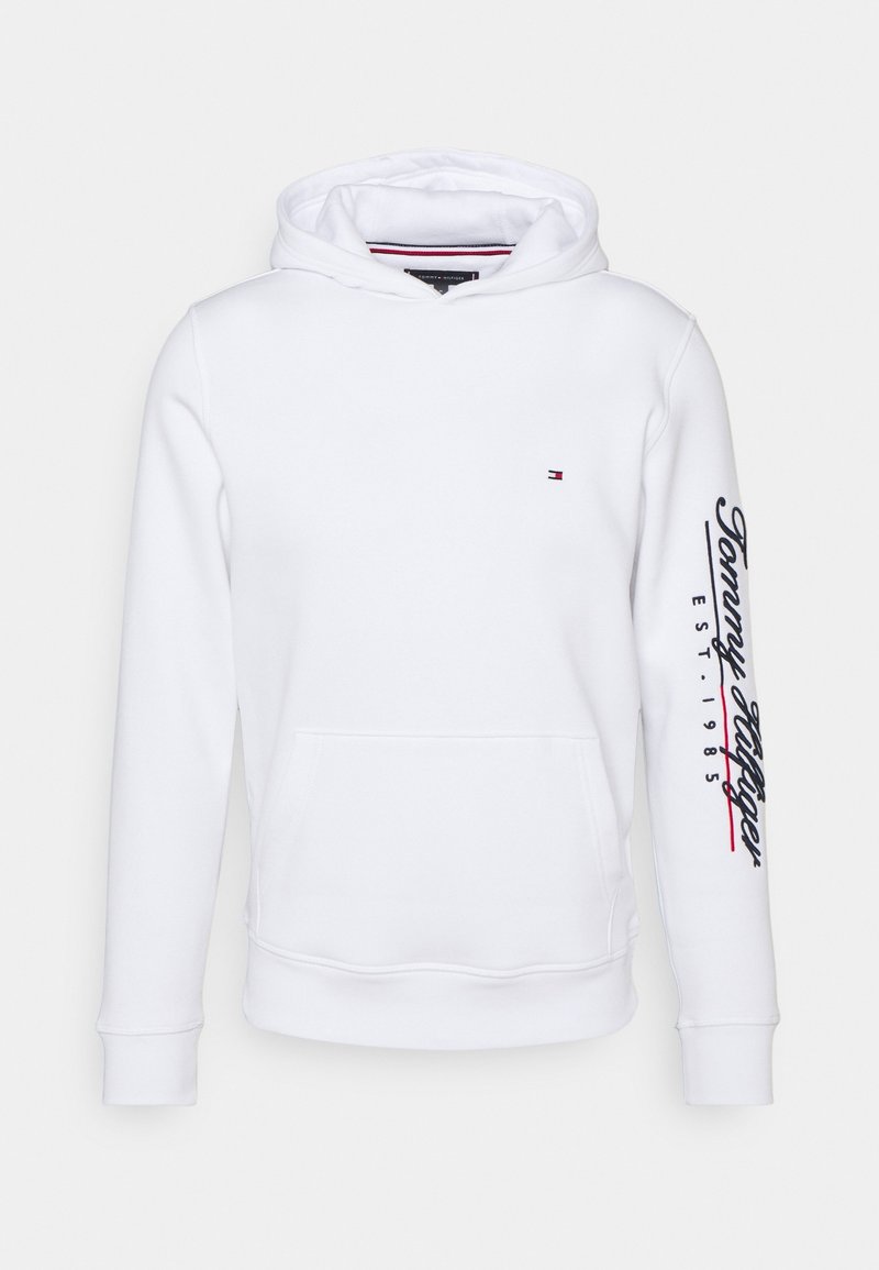 Sudadera blanca con un bolsillo frontal tipo pouch, capucha ajustable con cordón y texto impreso en rojo y azul marino en la manga izquierda.