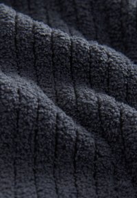 Dark gray fleece fabric with a textured, ribbed pattern. Soft, plush texture with a slightly raised design, suitable for various applications.