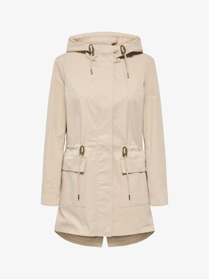 Beige hooded rain jacket with long sleeves, adjustable drawstrings at hood and waist, two large front flap pockets, and a slight fishtail hem.