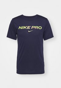 Camiseta Nike Pro de color azul marino con mangas cortas. Presenta un destacado logo "NIKE PRO" en varios colores y un pequeño logo swoosh de Nike debajo.