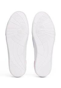 Bílé podešve tenisek s texturovaným gumovým gripem, s kruhovým vzorem a s embosovaným nápisem "TOMMY HILFIGER" v oblasti klenby.