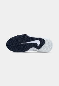 Black and white sneaker sole with textured grip pattern and white Nike swoosh logo centered on the black section of the sole.