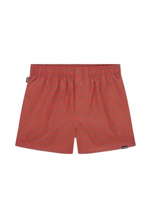 Boxers rouges en coton, avec un motif répétitif de petits "P" bleus. Ceinture élastique et une étiquette en bas à gauche.