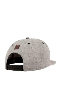 Grå caps med en teksturert overflate, justerbar bakstropp og en brun lærlappdetalj bak, med svarte ventilasjonshull.