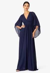 Abito lungo blu navy realizzato in tessuto fluido. Presenta un profondo scollo a V, un corpetto plissettato e ampie maniche fluide.