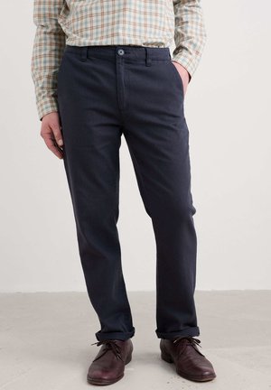 Donkerblauwe broek van lichtgewicht stof, met een klassieke rechte pasvorm, riemlussen en een frontale knoopsluiting. Opgerolde manchetten.