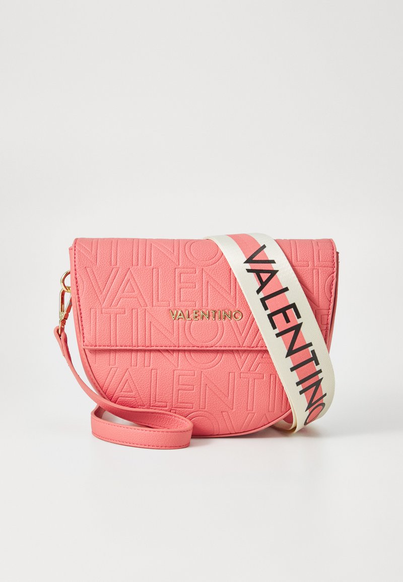 Rosa läder crossbody-väska med präglad "Valentino"-logotyp, guldfärgade detaljer och ett krämfärgat bälte med svart text. Kompakt rektangulär form.