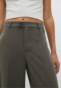 Skræddersyede grå brede bukser med glat tekstur, knaplukning, bæltestropper og flad front. Ingen synlige lommer.