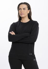 Maglione a maniche lunghe nero con scollatura rotonda, realizzato in un tessuto liscio, con un'etichetta con logo all'orlo e polsini a costine.