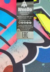 Tessuto colorato e decorato con elementi blu, rosa e neri. L'etichetta include istruzioni per la cura, colonna d'acqua 10K e traspirabilità 5K.