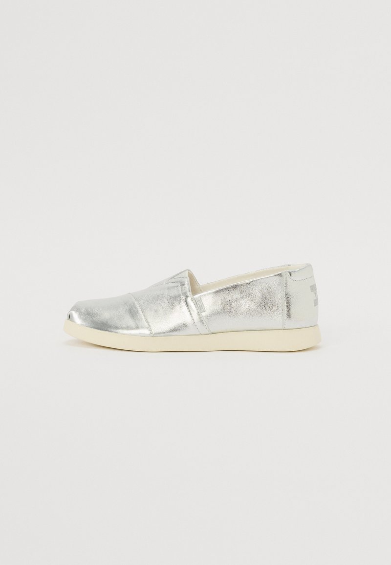 Silberne Slipperschuhe mit metallischem Finish, abgerundeter Zehenpartie, elastischen Seitenpaneelen und einer hellgrauen Gummisohle. Einfaches Design ohne Muster oder Akzente.