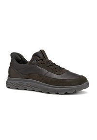 Zapatos deportivos oscuros que combinan cuero suave y ante, con una suela de goma texturizada y diseño de cordones.