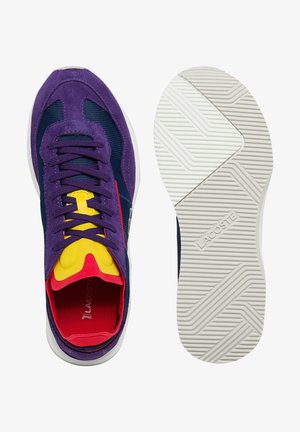 Lacoste sneakers i lilla ruskind og mesh, med gule og røde accenter, samt en hvid gummisål med et struktureret mønster.