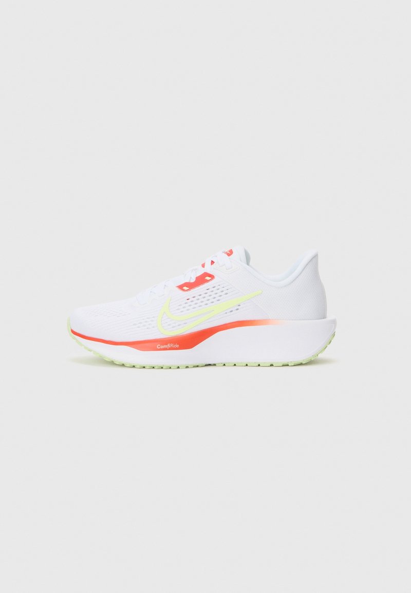 Chaussure de course blanche avec un swoosh Nike vert clair et des détails orange sur la semelle et la zone des lacets, vue de côté sur un fond clair.