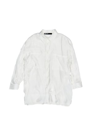 Camicia bianca con bottoni in tessuto trasparente e texture liscia. Presenta due tasche frontali e maniche lunghe con dettagli a polsino.