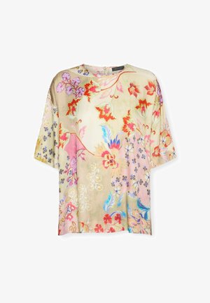 Luźna bluzka z krótkim rękawem na beżowym tle, zdobiona czerwonymi, różowymi, niebieskimi i fioletowymi wzorami kwiatowymi oraz okrągłym dekoltem.