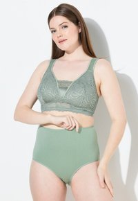 Groene kanten bralette met brede bandjes, V-hals ontwerp en bloemmotief. Hoge taille groene slips met een gladde textuur, in bijpassende kleur.
