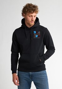 Černá mikina s kapucí, která má přední kapsu a vícebarevný abstraktní design na prsou. Měkká látka s žebrovanými manžetami.