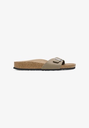Cork footbed slide sandal with a beige suede strap, featuring a metallic buckle detail and a black rubber outsole for grip.