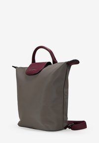 Bolso tote de nailon gris con solapa de cuero burdeos, asas superiores redondeadas y correa de hombro desmontable. Textura suave y diseño minimalista.