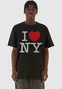 Čierne tričko s krátkym rukávom a veľkým grafickým výtlačkom "I ♥ NY" v červenej a šedej farbe, s voľným strihom a okrúhlym výstrihom.