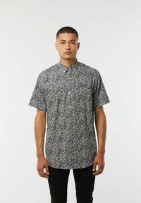 Korte mouw knoopshirt in zwart met een wit bloemenpatroon. Heeft een klassieke kraag en een rechte snit. Soepele stofstructuur.