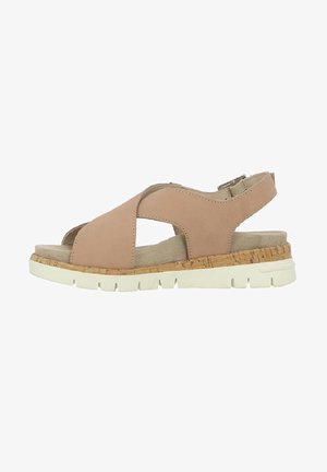 Sandale beige avec des brides croisées, semelle intermédiaire en liège et semelle en caoutchouc blanche. Comprend une boucle ajustable et une doublure intérieure douce.
