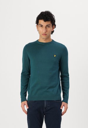 Maglione verde a maglia con maniche lunghe, scollo rotondo e polsini a coste. Presenta un piccolo logo dorato sul lato sinistro del petto.