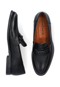 Czarne skórzane mokasyny o gładkiej fakturze, z dekoracyjnym metalowym akcentem na cholewce oraz brązową wyściółką.